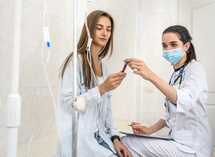 Point of Care Diagnostic Testing Patient in hospital with doctor holding clipboard