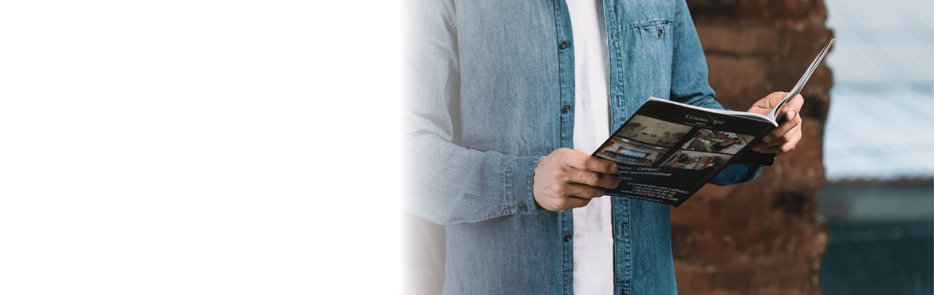 man in denim jacket reading magazine