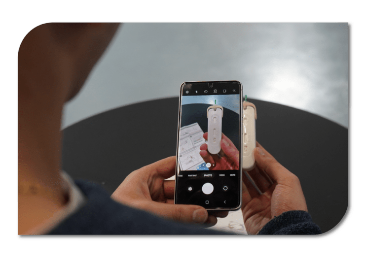 Atomo-App-Demonstration A person holding a smartphone with a camera, ready to take a photo.